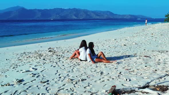 Ladies look beautiful on marine tourist beach trip by blue lagoon with white sandy background of Gil