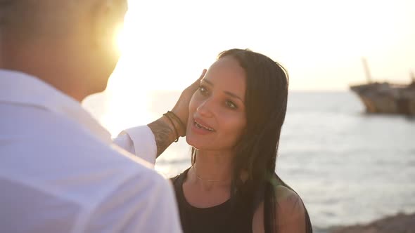 Portrait of Happy Loving Beautiful Slim Caucasian Woman in Sunshine with Man Touching Hair Talking