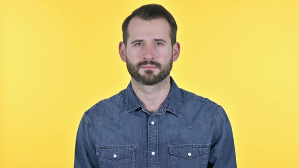 Young Man Looking at Camera, Yellow Background