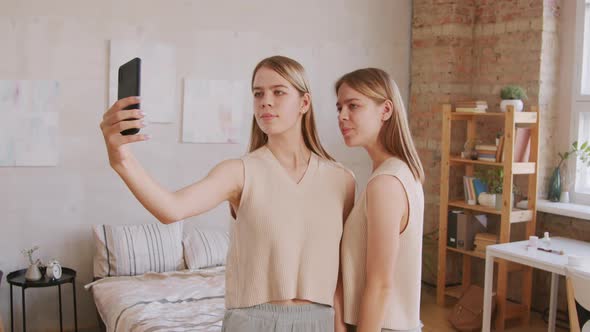 Happy Twin Sisters Taking Selfie on Mobile Phone