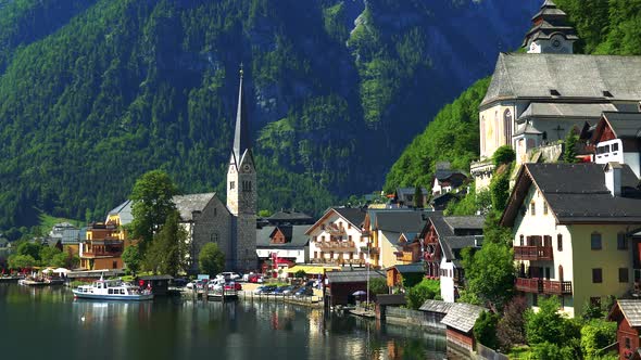 Village Hallstatt with Church in Summer Day - Mountains and Forests in the Background