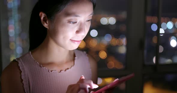 Woman working on cellphone at night 