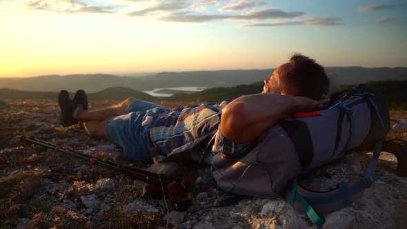 Tourist Lying on Ground and Watching Sunset From Rock Mountain Hike Travel Spbd