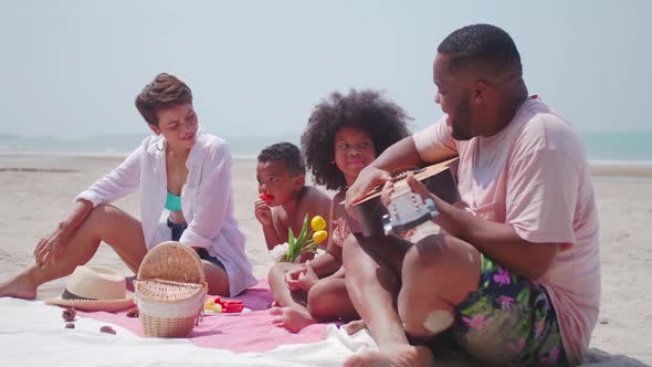 Parents and two children are relaxing together on the beach.