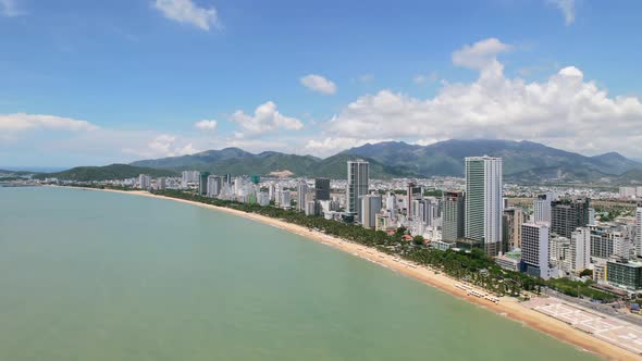 wide aerial drone of Nha Trang on a sunny summer day with camera moving towards the coastline and wh