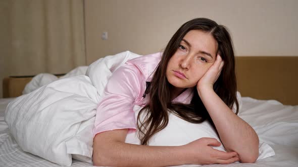 Sad Woman Sighs Deeply Lying on King Size Bed Lonely