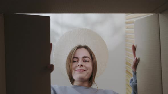 Positive Caucasian Woman Looking Inside Cardboard Box