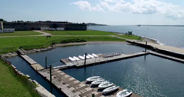 A drone flies across the diagonal tip of Newport Rhode Island's bay near Fort Adams to reveal docks