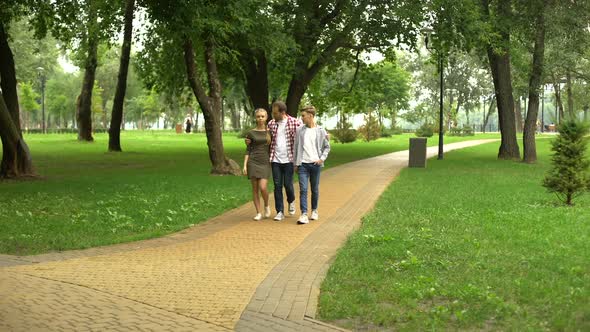 Caring Father Walking With Teenage Children in Park, Family Weekend Outdoors