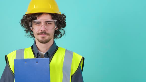 Young Arhitect with Safety Glasses and Helmet That is Looking at Camera