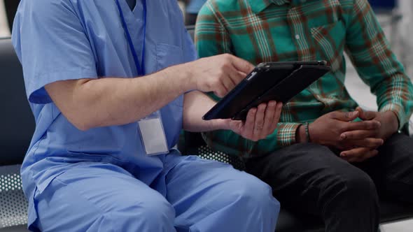 African American Man and Male Nurse Looking at Digital Tablet