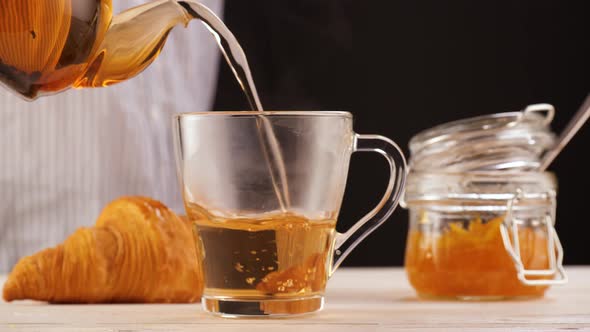 Anonymous Person Pouring Tea Near Desserts