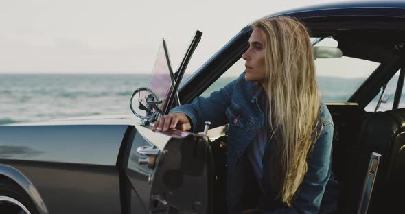 Beautiful woman sitting in a vintage sports car