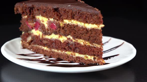 Chocolate cream cake with custard. Piece of chocolate cake rotate, close up
