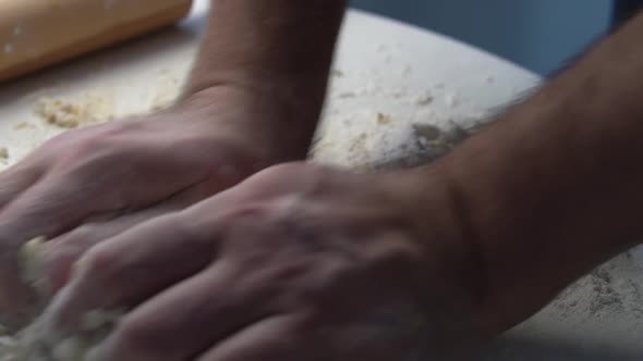 Closeup Shot of Male Hands Ff Baker Kneading Dough in Flour on Wooden Table at Home