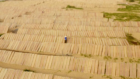 Drone view of a worker is drying rice paper on the Rice paper village in Binh Dinh province, central