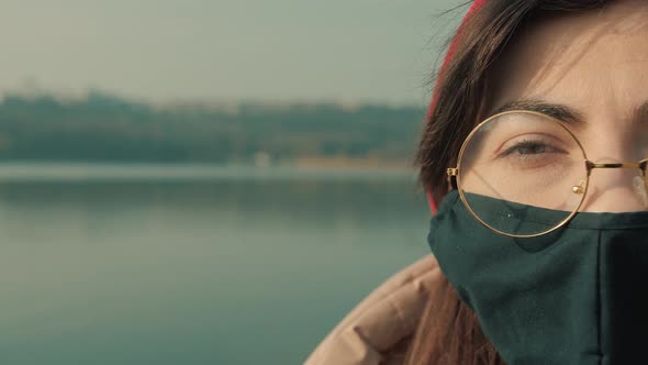 Half face of young woman in black mask