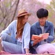 Happy young couple dating while pink Sakura park on Valentine day. - VideoHive Item for Sale