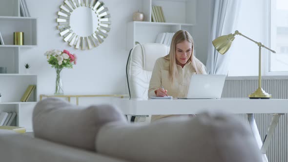 Smiling young woman communicating by video live using computer