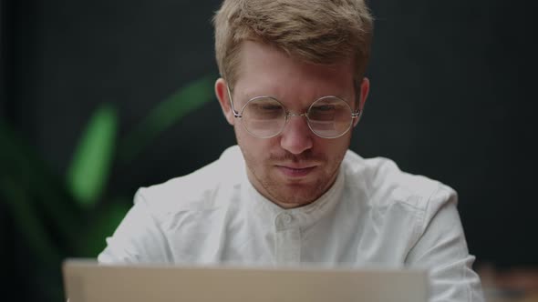 Handsome European Man is Reading News on Screen of Laptop in Home or in Office Portrait of Thinking