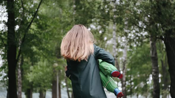 Funny Kid in Rain Boots Playing in a Rain Park