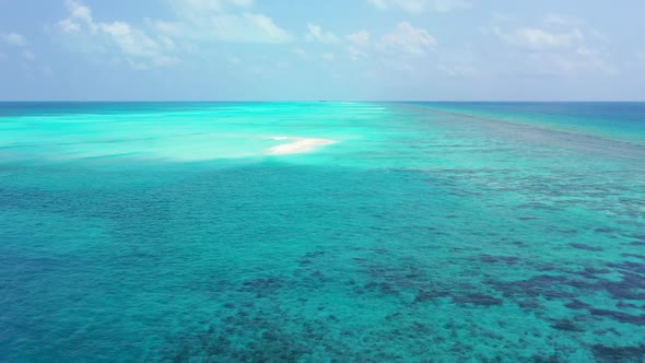 Aerial flying over scenery of idyllic bay beach lifestyle by blue sea and white sandy background of 