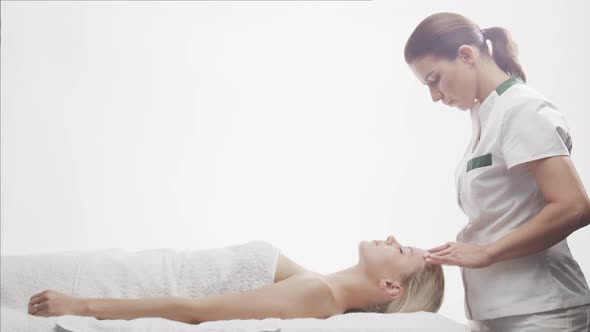 Young, healthy and beautiful woman gets massage therapy in the spa salon.