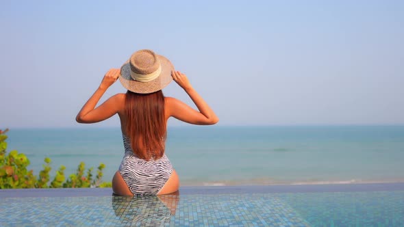 Young asian woman enjoy around outdoor swimming pool for leisure