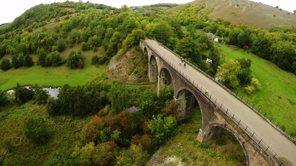 Aerial view cyclists and hikers crossing Headstone Viaduct, bridge in the Derbyshire Peak District N