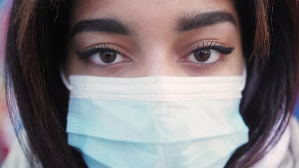 Close Up Sad Face of Mixed Race Woman in Medical Face Mask Against Air Pollution and Coronavirus