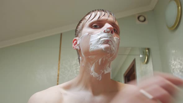 Man Shaves His Face