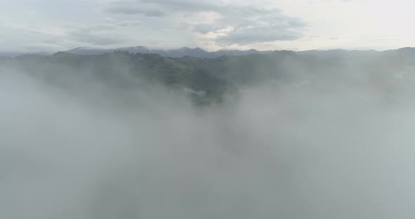 Drone Flying Through Dense Fog in the Mountains in Cloudy Summer Day