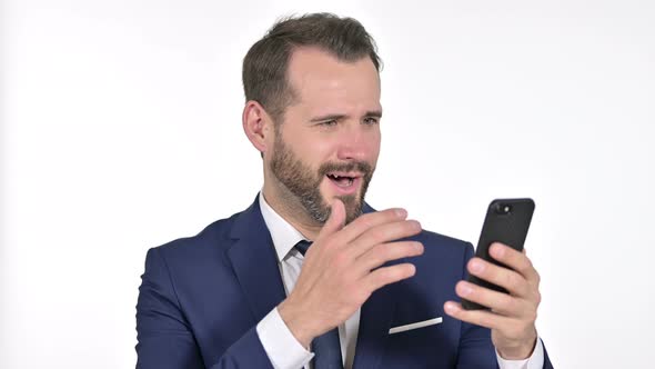 Cheerful Businessman Celebrating on Smartphone, White Background