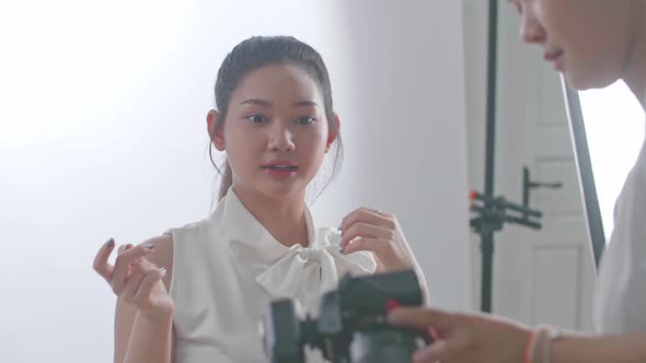 Young Asian Female Photographer Showing Photos To The Asian Model In Studio