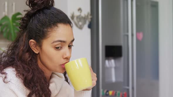 Thoughtful woman looking away while having coffee in the kitchen 4K 4k