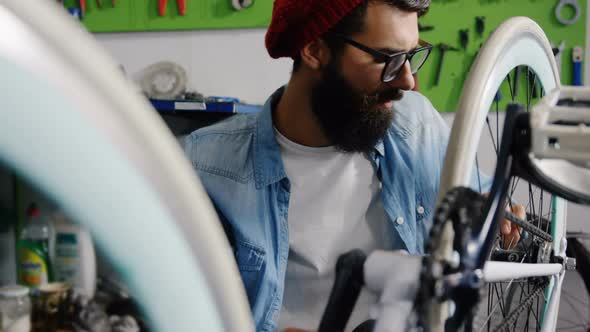 Mechanic repairing bicycle in workshop