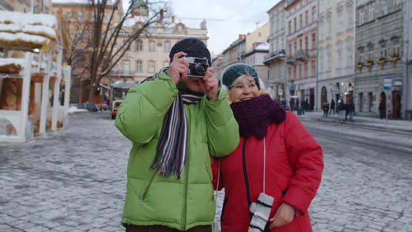 Senior Wife Husband Tourists Taking Photo Pictures on Retro Camera Walking on Winter City Street