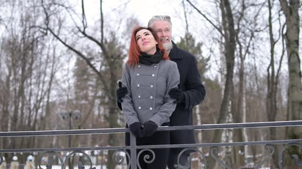 Two lovers in the park, husband and wife - gray-haired man and a young woman