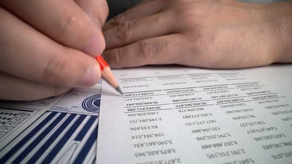 Accountant Analyzing Business Marketing Data on Paper Dashboard at Office Table