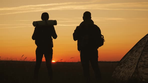 Silhouette Tourist Couple Standing Holding Hands and Watching the Sunset Near Tent in Vacation. Camp