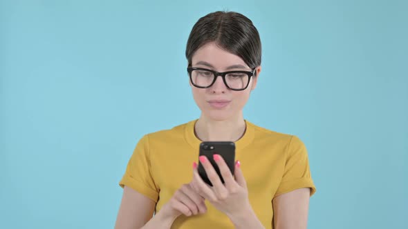 Young Woman Using Mobile Phone on Purple Background