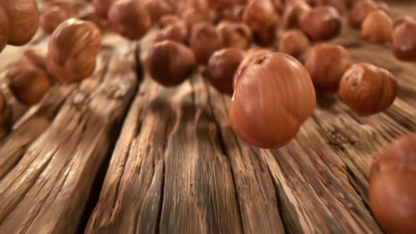 Super Slow Motion Detail Shot of Hazelnuts Rolling Towards on Wooden Background at 1000Fps