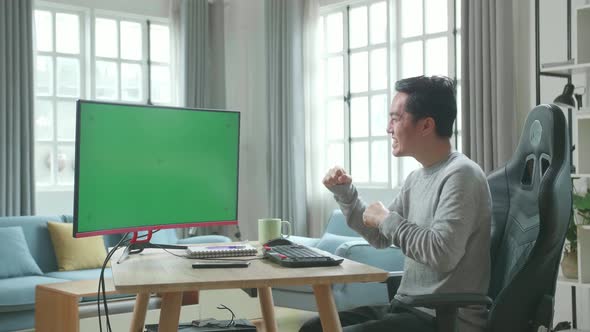 Asian Man With Green Screen Desktop Computer Being Happy Successful In Work While Working At Home