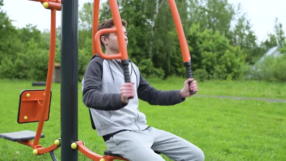 A teenager is training on a sport machine using an athlete's own weight.