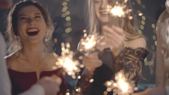 Close Up of Palms Lighting Latch or Fire Holding and Waving Sparklers