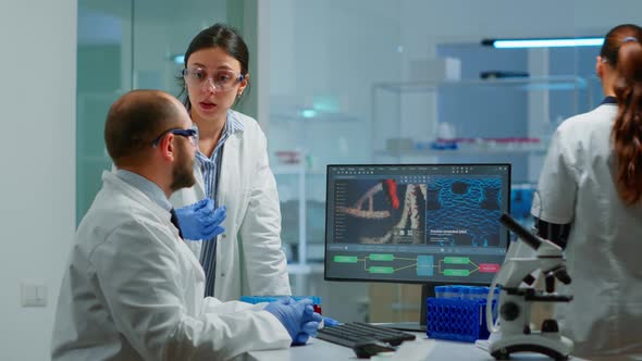 Team Medical Scientist Conducting DNA Experiments Looking in Computer