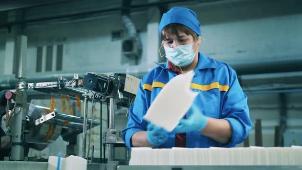 Female Person Separating Paper Tissues and Placing Them Onto a Conveyor