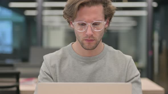 Portrait of Businessman Working on Laptop in Office