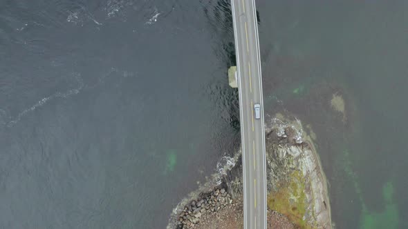 View Of Vehicle Crossing Storseisund Bridge in Atlantic Ocean Road, Norway. - Drone shot, top down