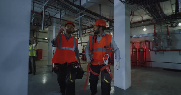 Male Workers Walking and Talking on Factory